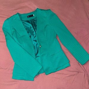 Green blazer with loose, ruffled bottom.